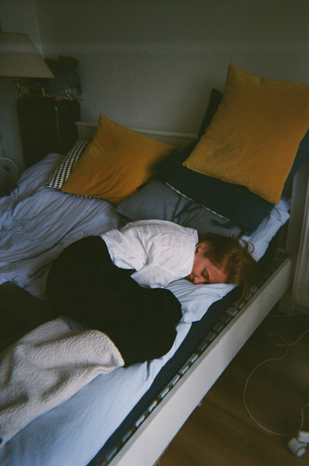 a person laying on a bed with a blanket