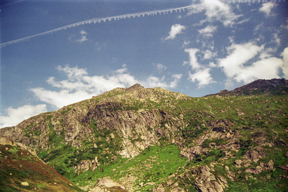 Un avion survolant une colline verdoyante