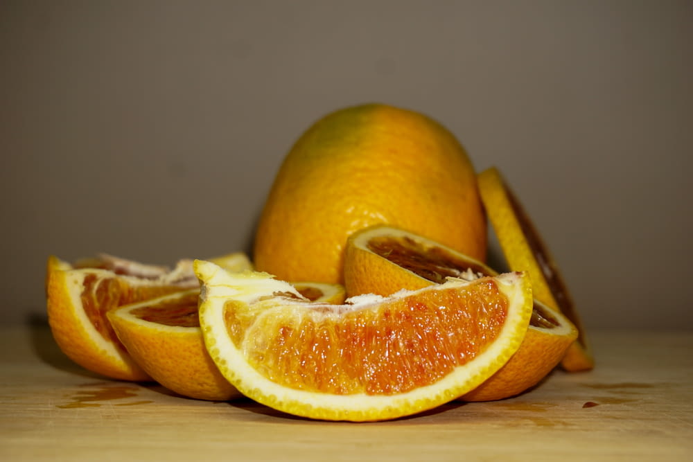 a pile of oranges sitting on top of a wooden table