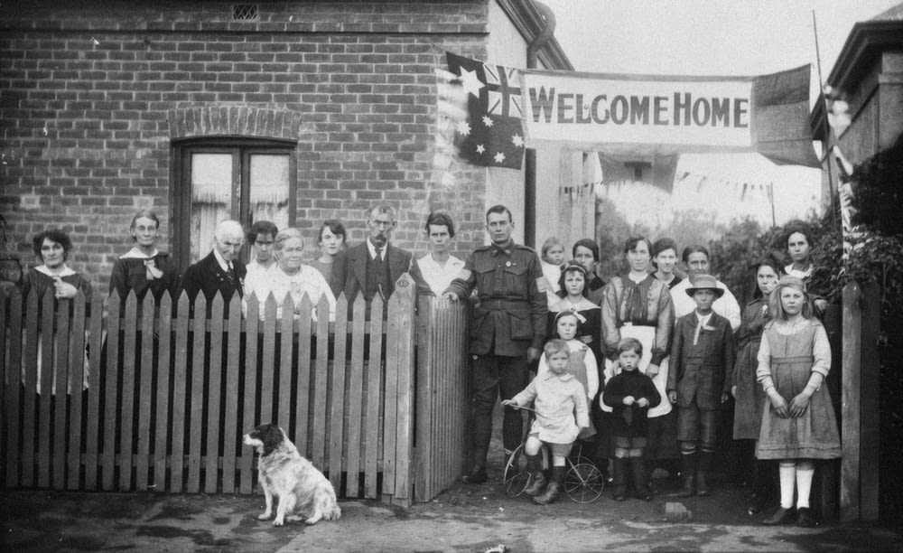 a black and white photo of a group of people and a dog