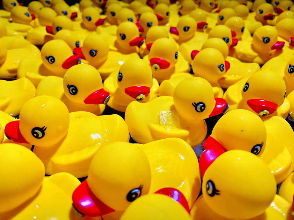 a bunch of rubber ducks that are yellow and red