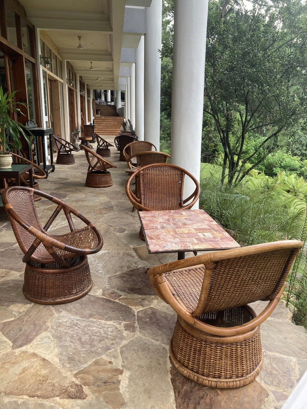 a row of wicker chairs sitting on top of a stone floor