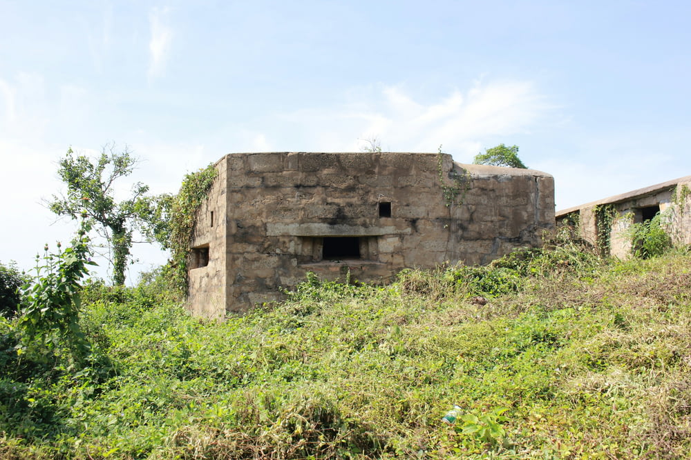 a stone building sitting on top of a lush green hillside