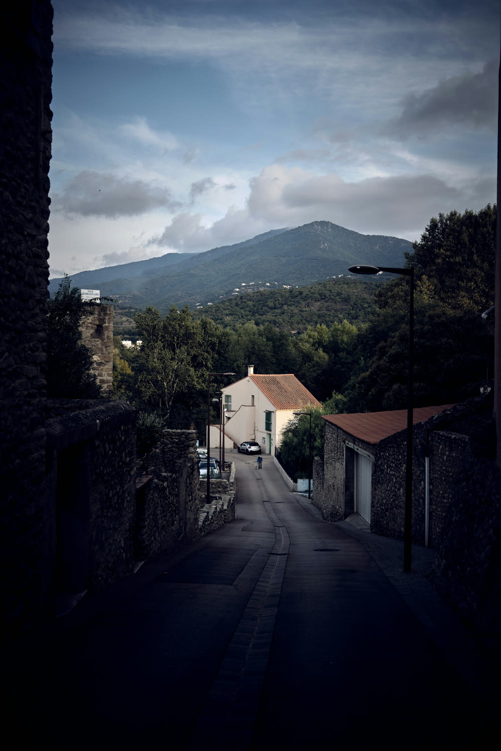 a dark street with a mountain in the background