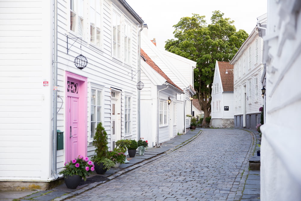 a cobblestone street lined with white houses