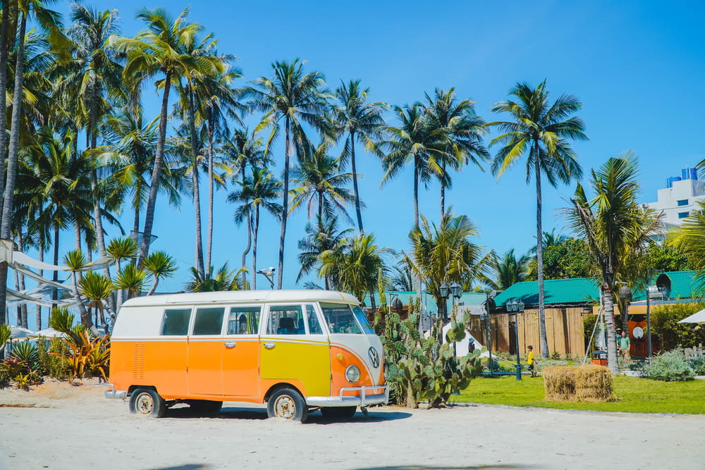 an orange and white van parked in front of palm trees