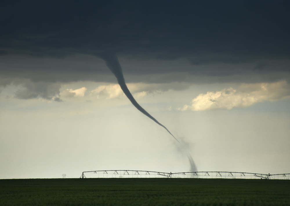 a tornado is seen in the sky over a field