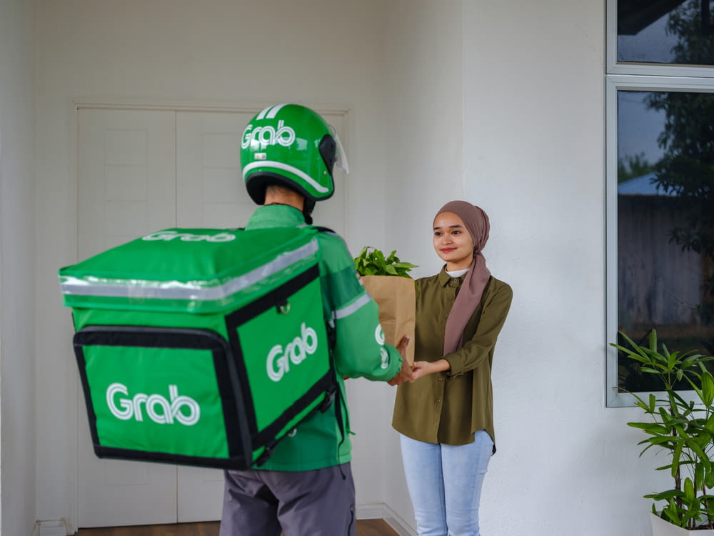 a man and a woman holding a giant green box