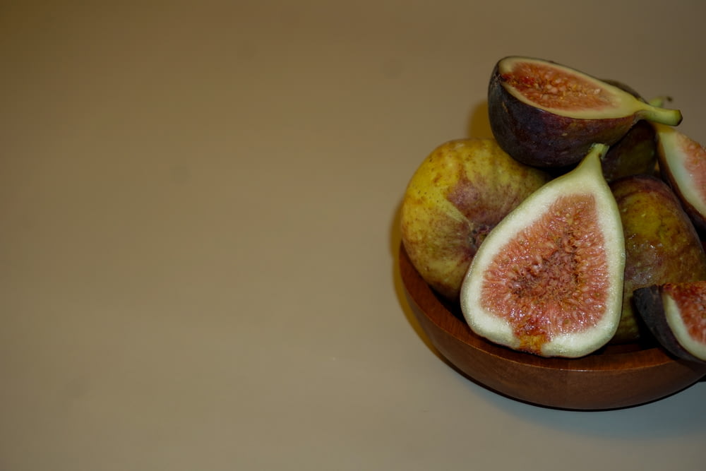 a bowl filled with sliced figs on top of a table
