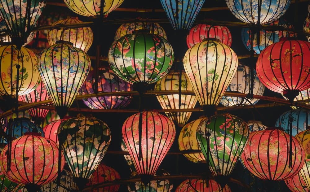 a bunch of colorful lanterns hanging from a ceiling