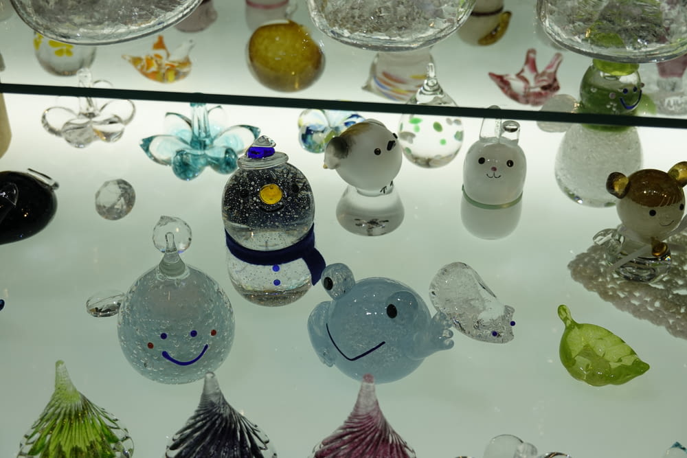 a glass display case filled with glass figurines