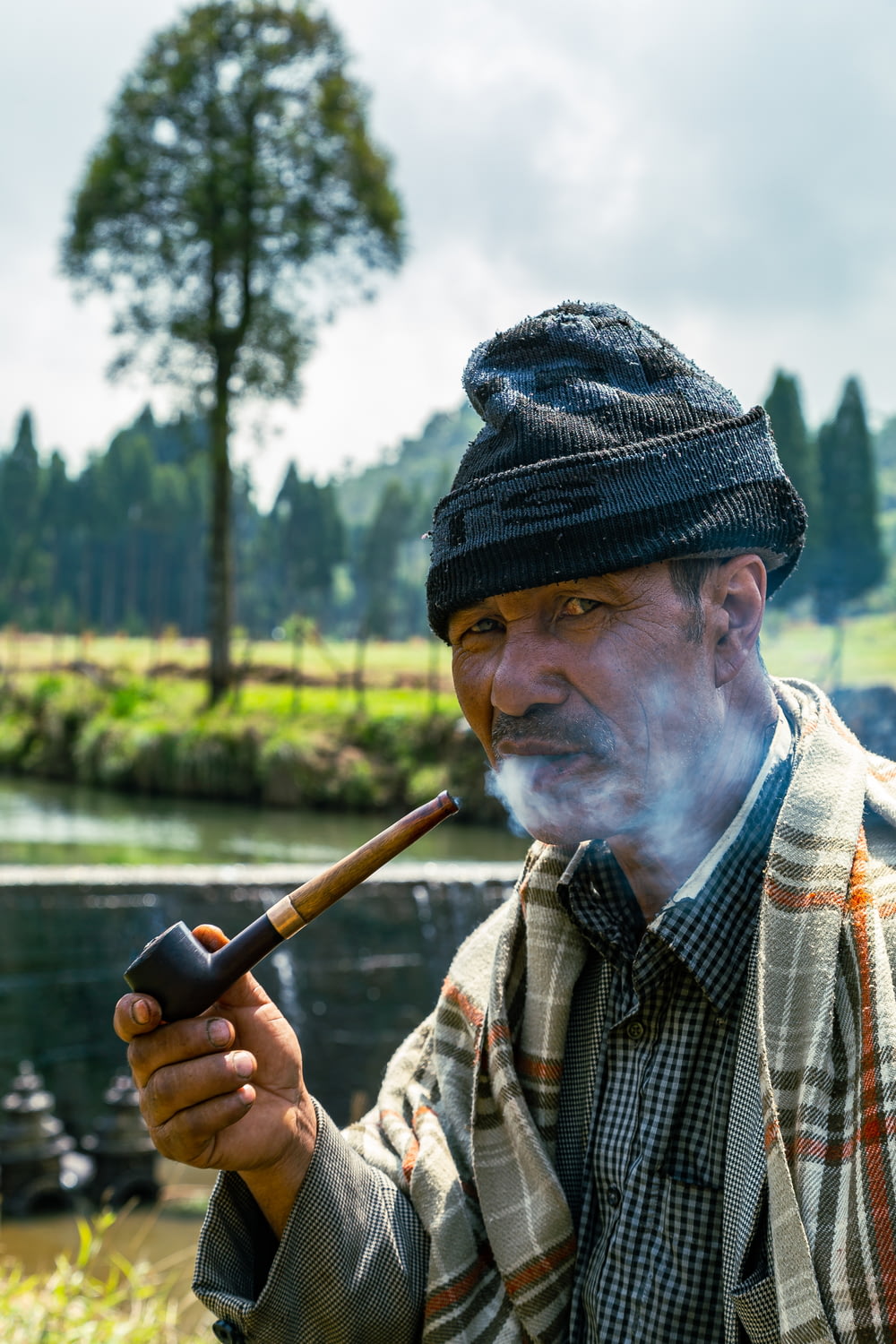 a man smoking a pipe in a park