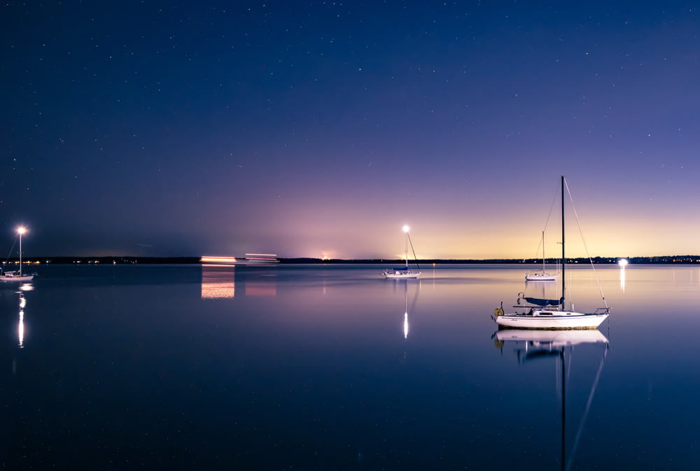 a sailboat floating on a lake at night