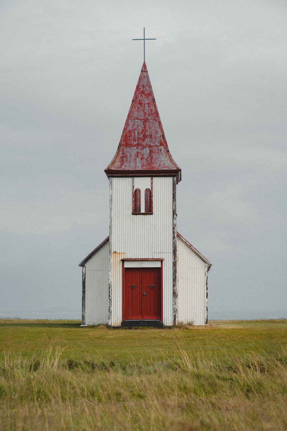 a white church with a red door and steeple