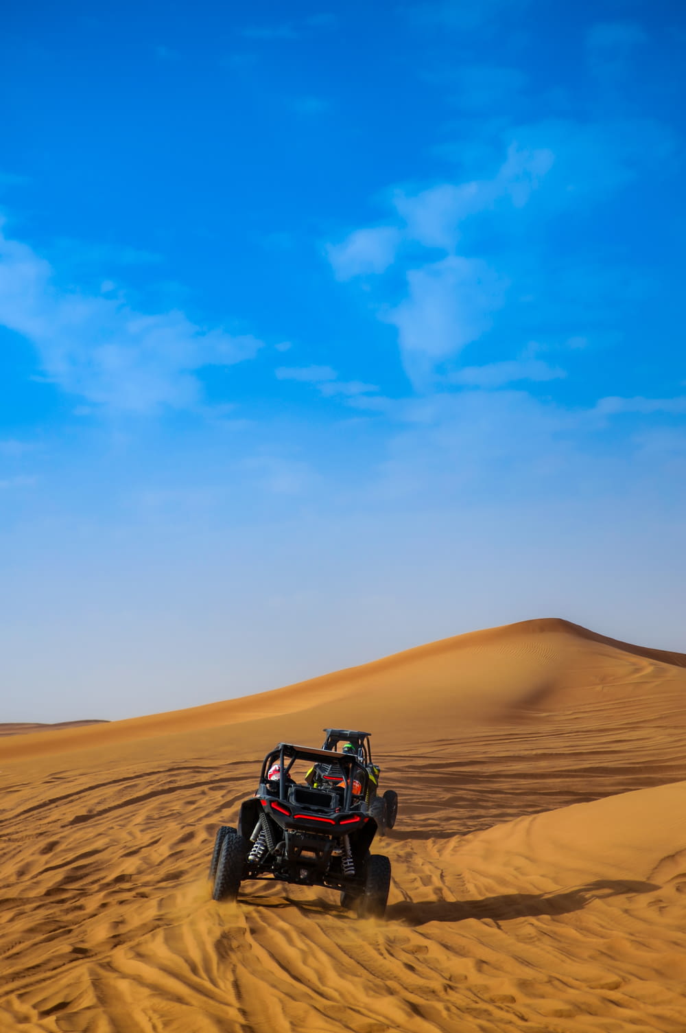 a four - wheeler driving through the desert on a sunny day