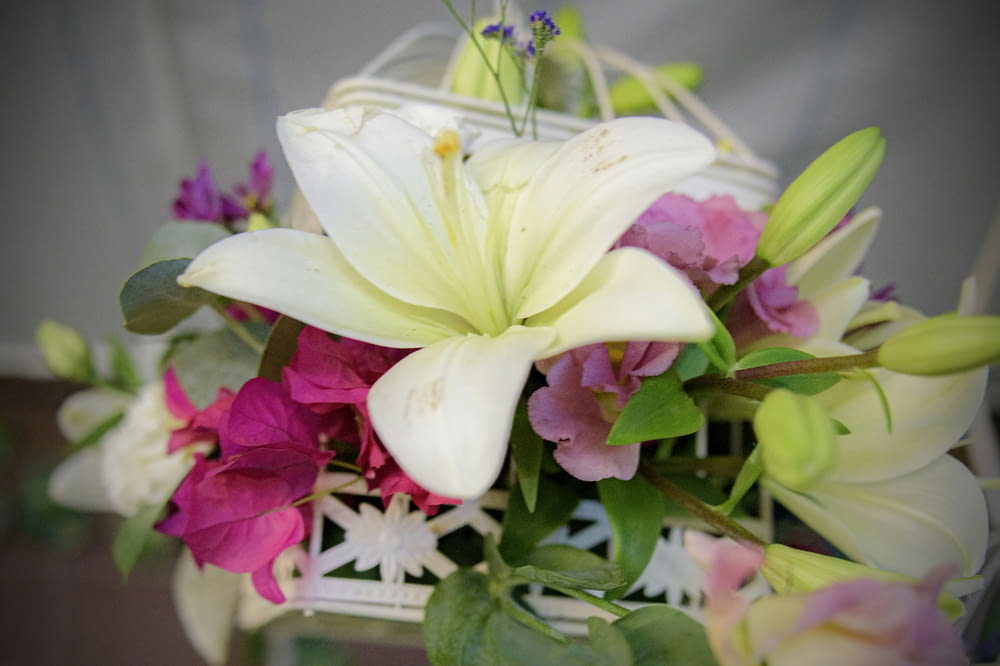 a bouquet of white and pink flowers in a basket