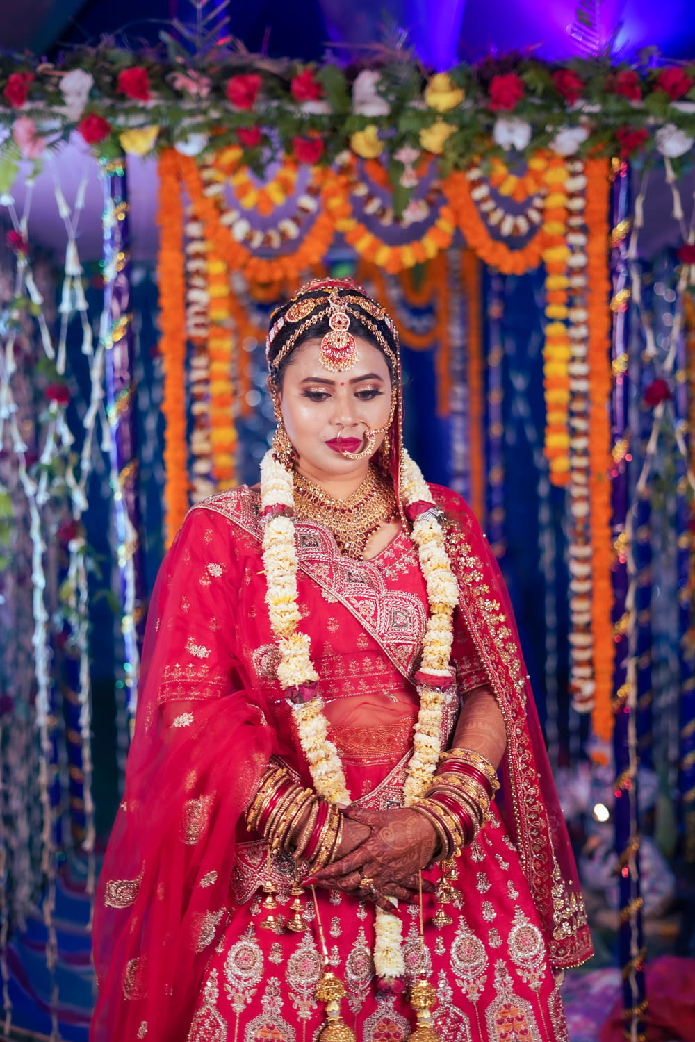 a bride dressed in a red and gold lehenga