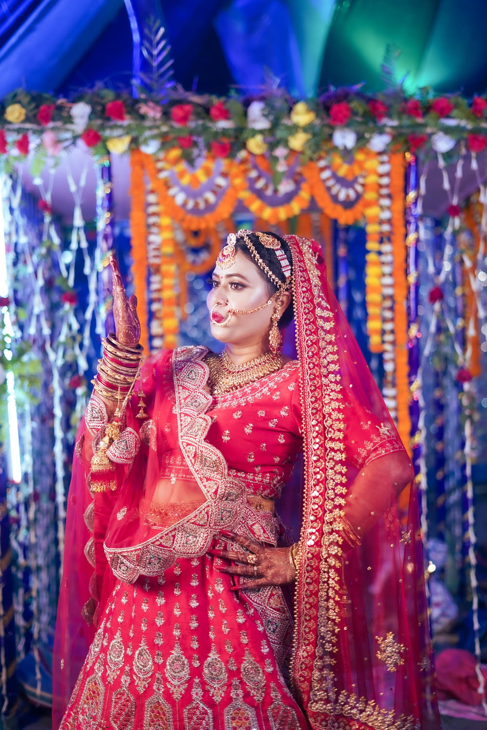 a woman dressed in a red and gold bridal outfit