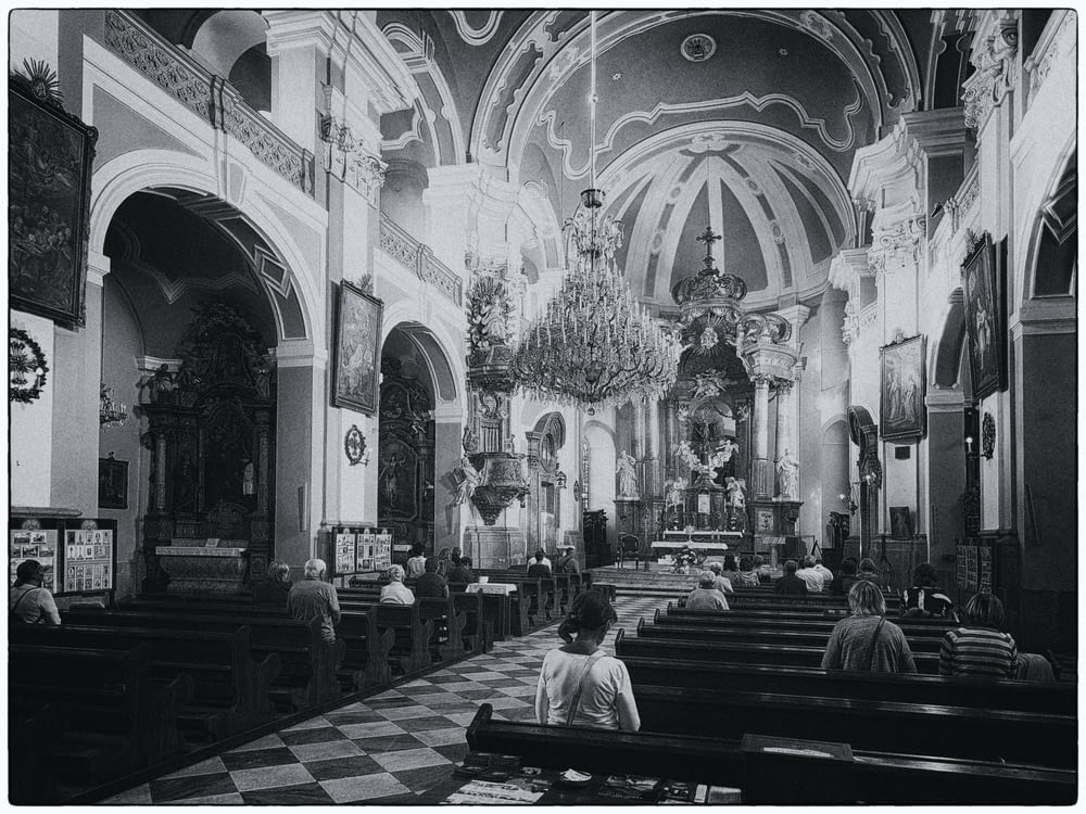 a black and white photo of people in a church