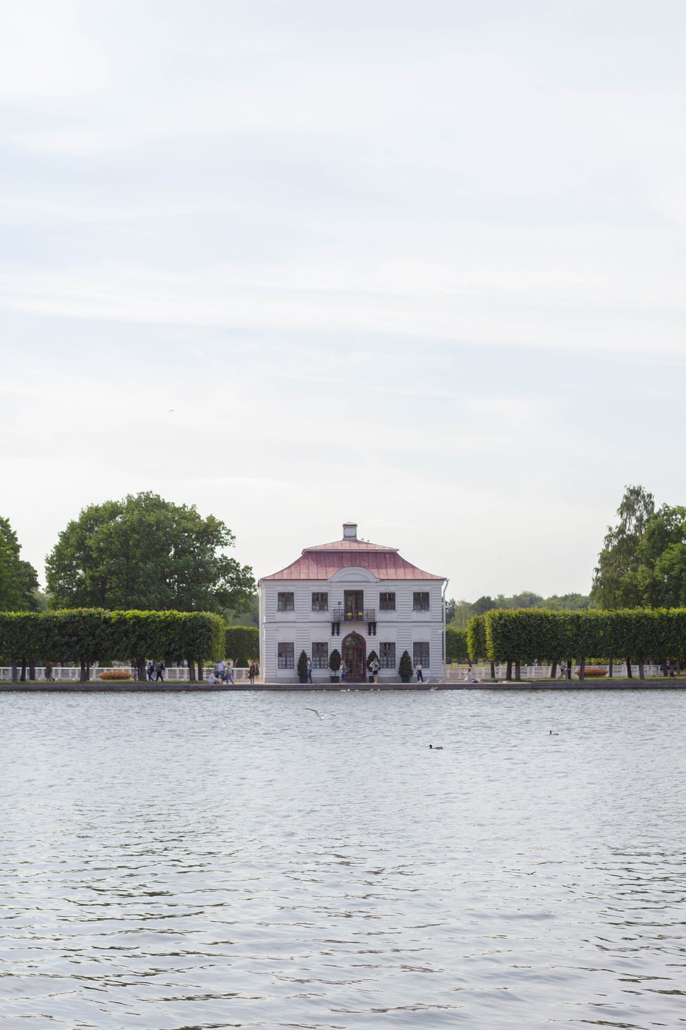 a large white house sitting on top of a lake