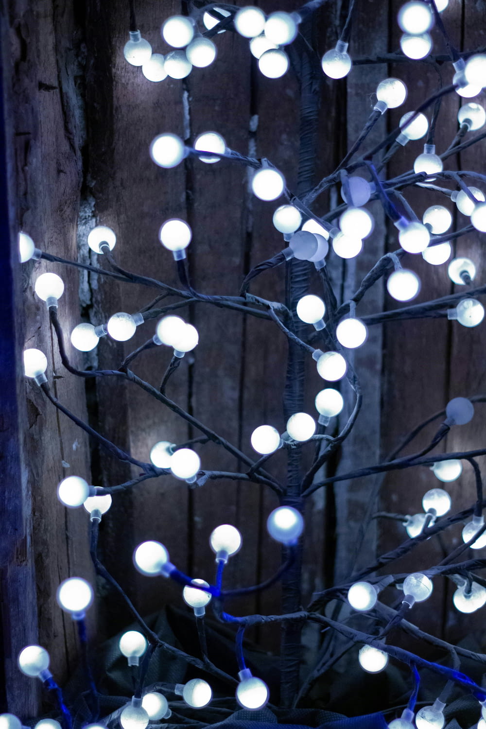 a lighted tree with white balls on it