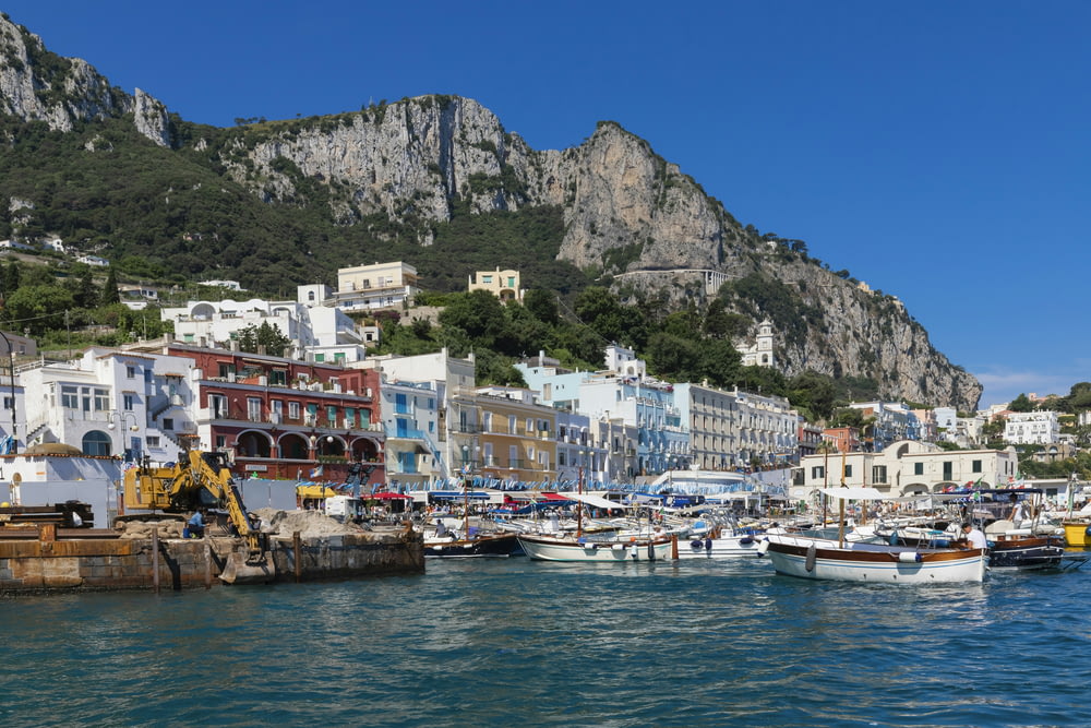 a harbor filled with lots of boats next to a mountain