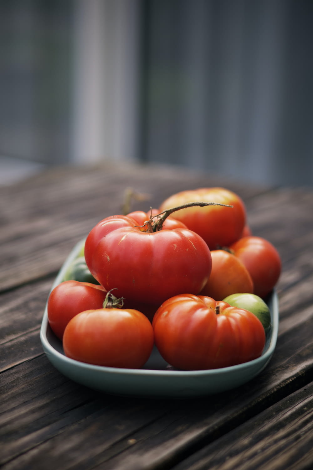 a plate of tomatoes on a wooden table