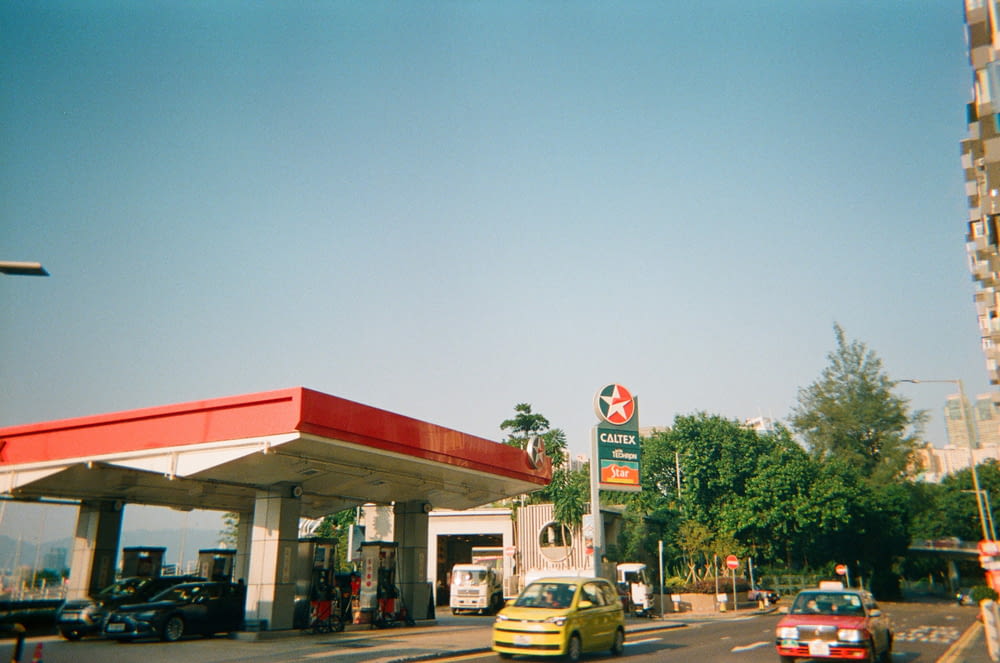 a gas station with cars parked at the gas pump