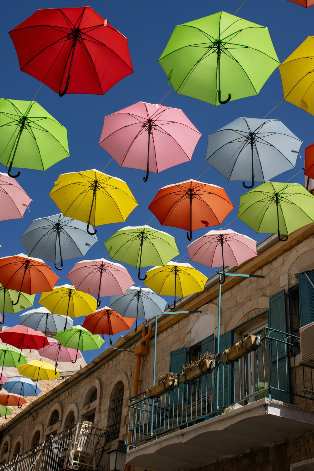 a group of multicolored umbrellas flying in the air