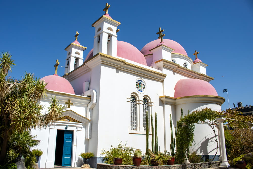 a white church with pink domes and a blue door