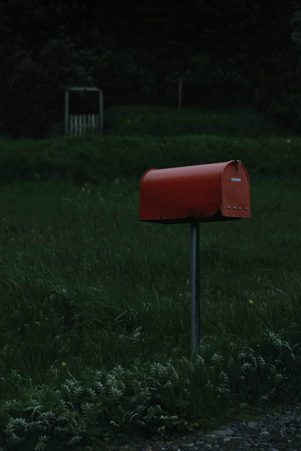 a red mailbox sitting in the middle of a field