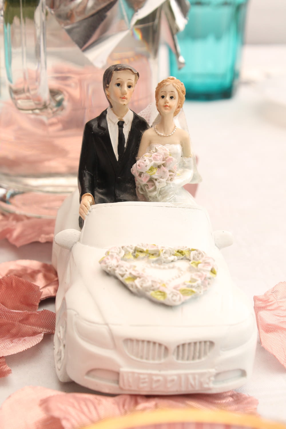 a wedding cake topper of a bride and groom on a car