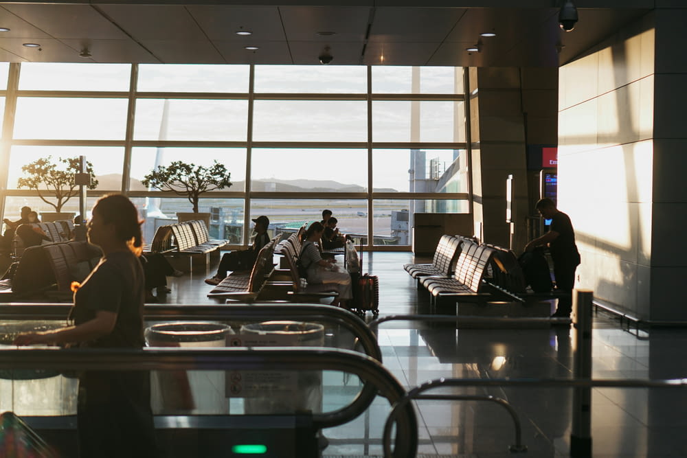 um homem sentado em um aeroporto esperando por sua bagagem