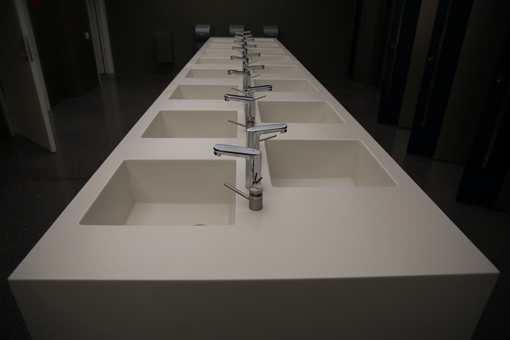 a row of white sinks in a room