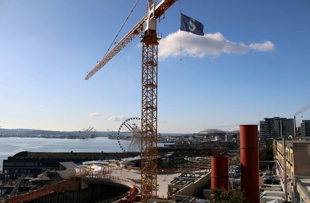 a crane on top of a building next to a body of water