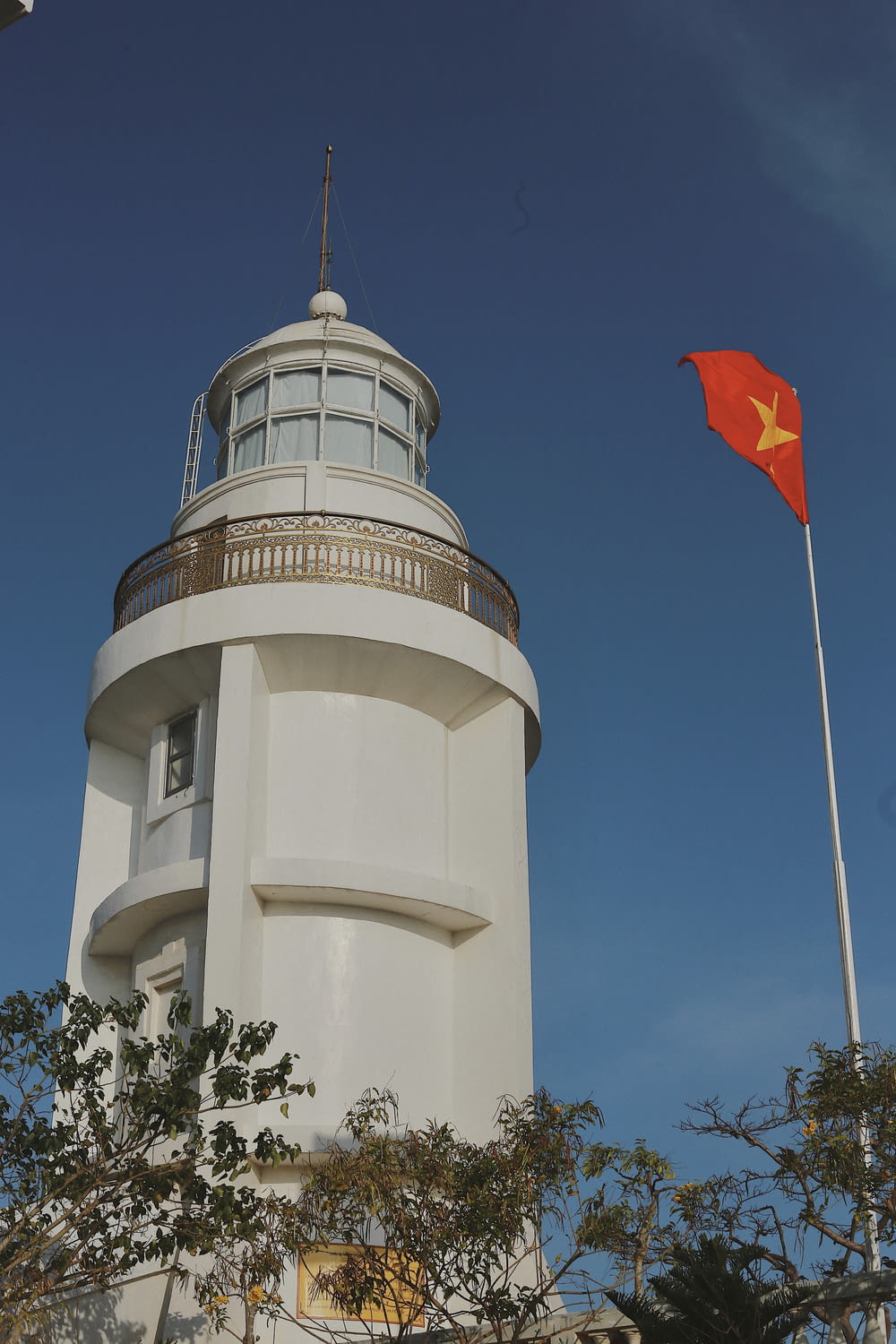 a large white tower with a red flag on top of it