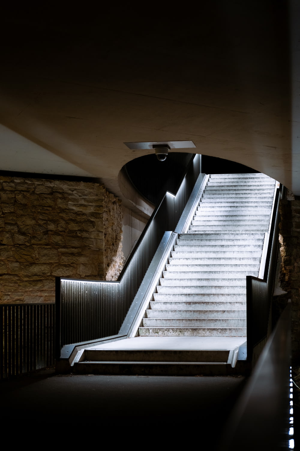 an escalator in a building with stone walls