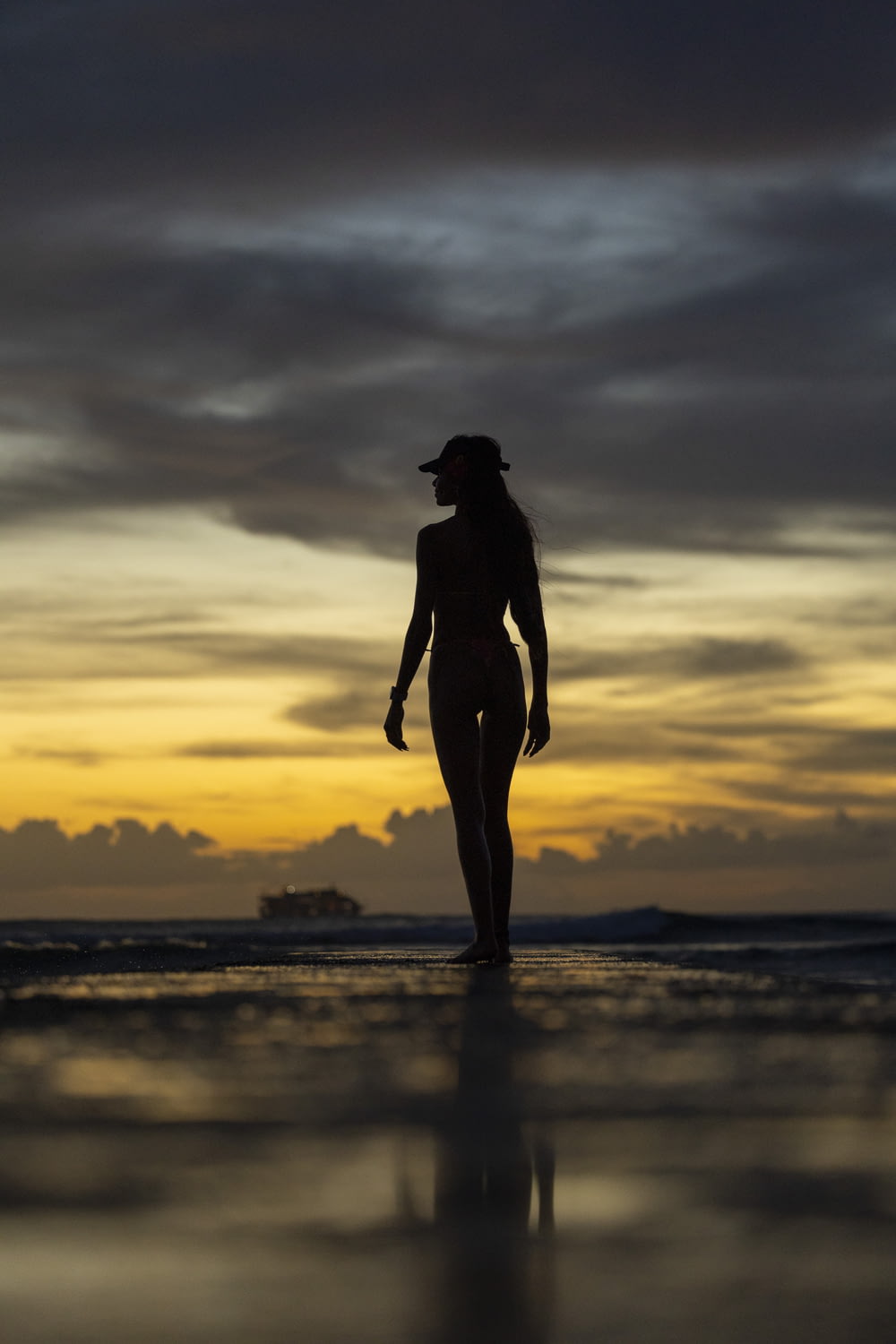 Une femme marchant sur la plage au coucher du soleil