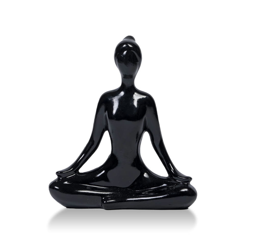 a black statue of a person sitting in a yoga position