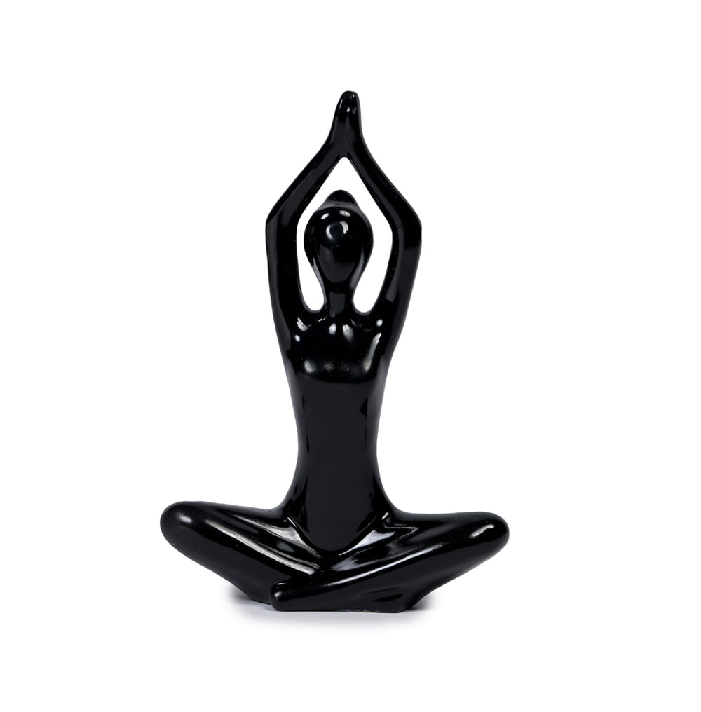 a black statue of a person doing yoga