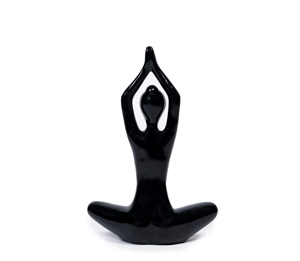 a black statue of a person doing yoga