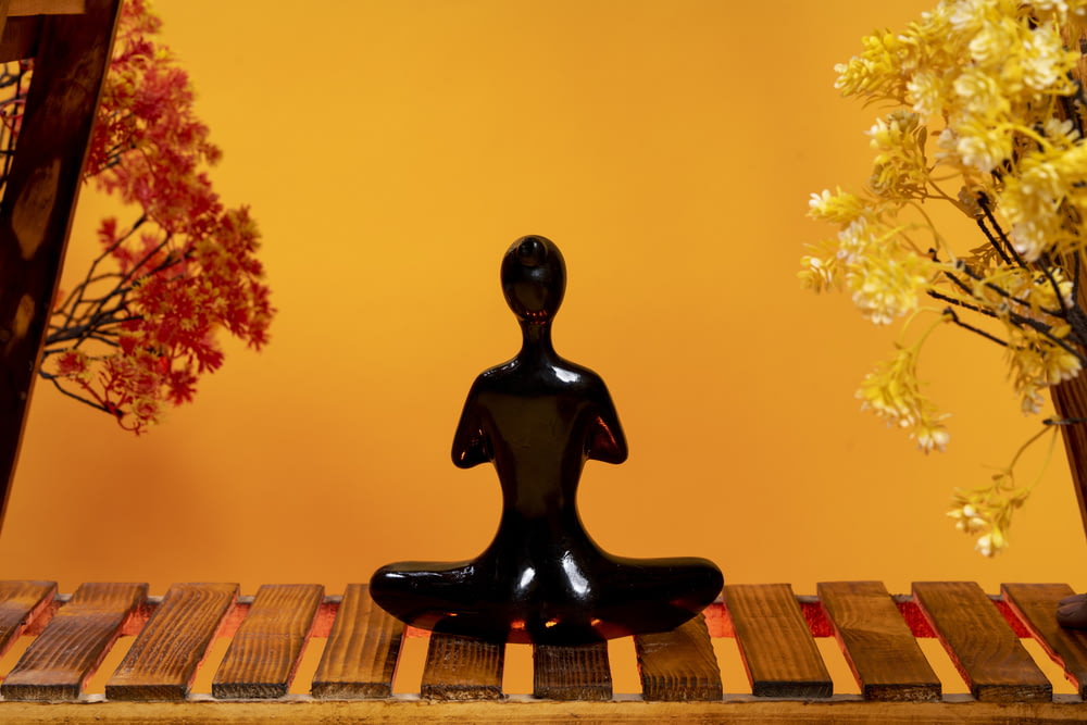 a black statue sitting on top of a wooden table