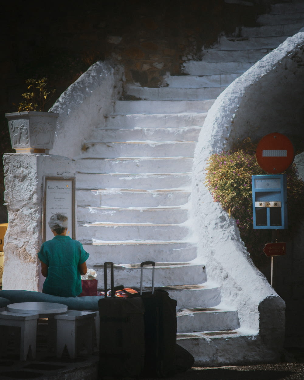 a man sitting on a set of stairs next to luggage