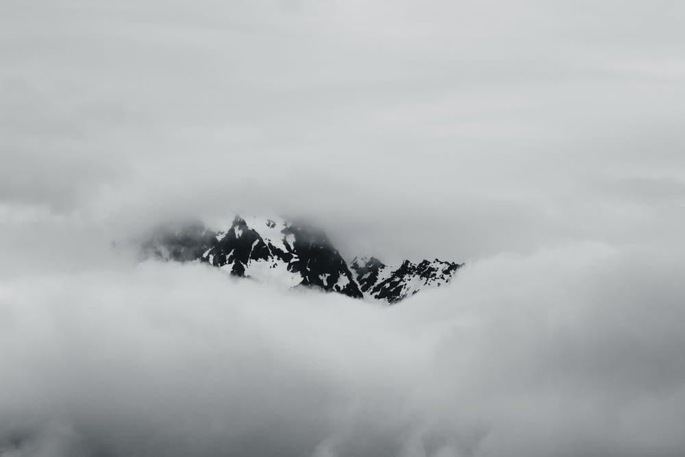 Una foto en blanco y negro de una montaña cubierta de nubes