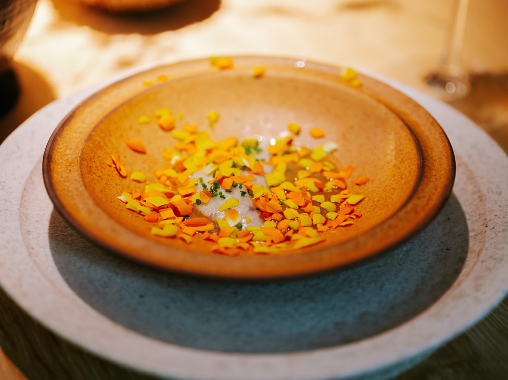 a plate with a small bowl of confetti on top of it