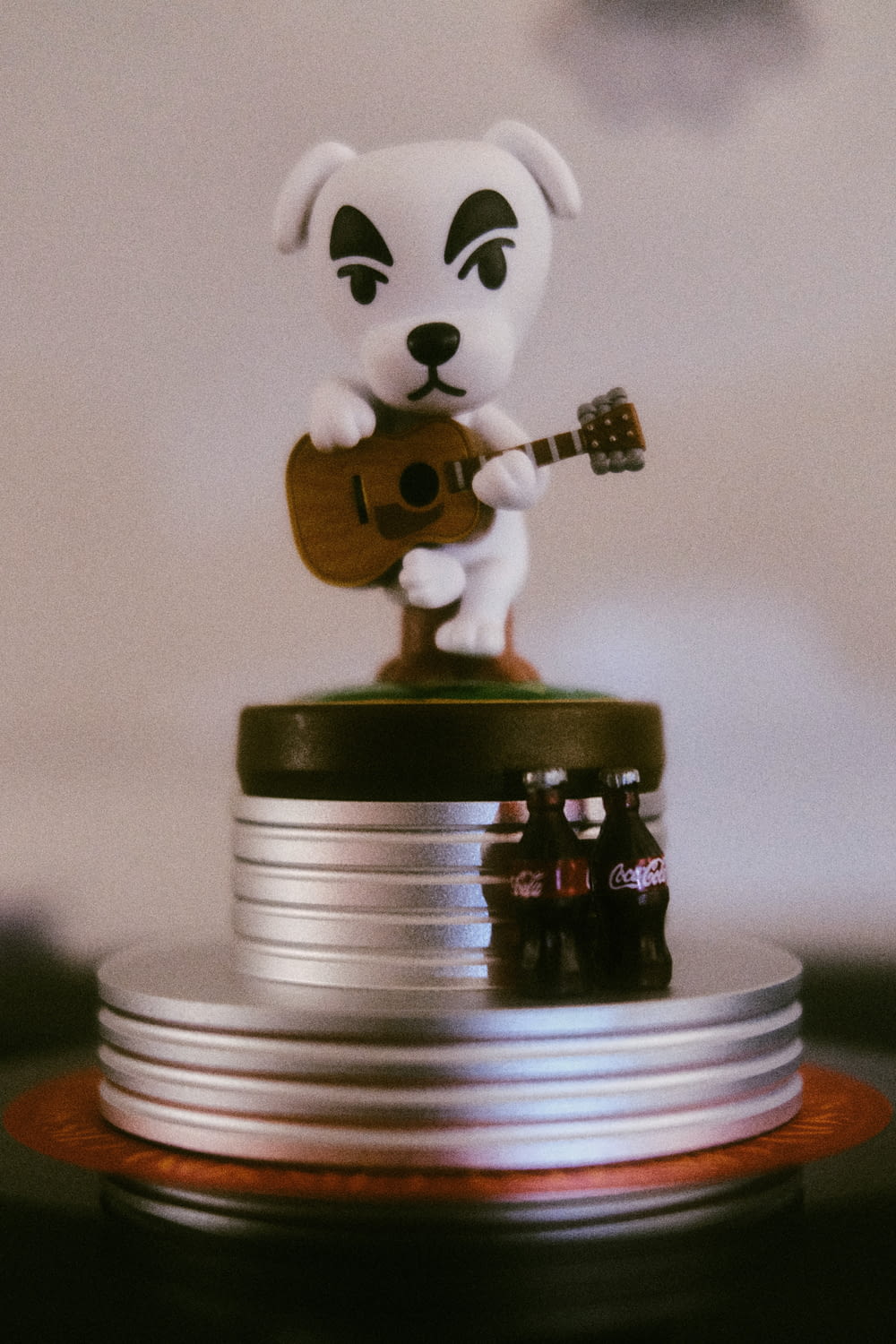 a toy dog playing a guitar on top of a stack of coins