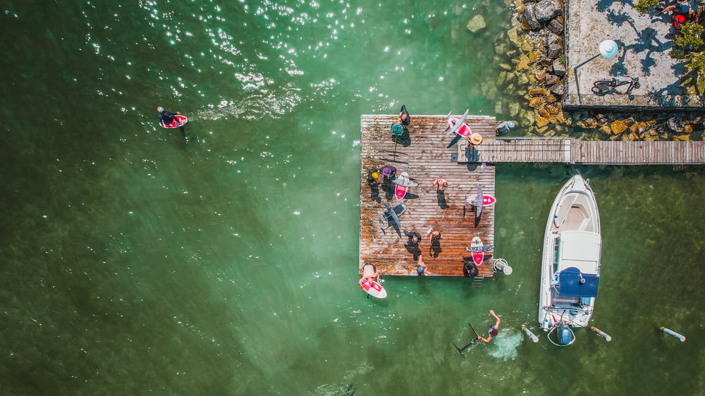 Un gruppo di persone in piedi su un molo accanto a una barca