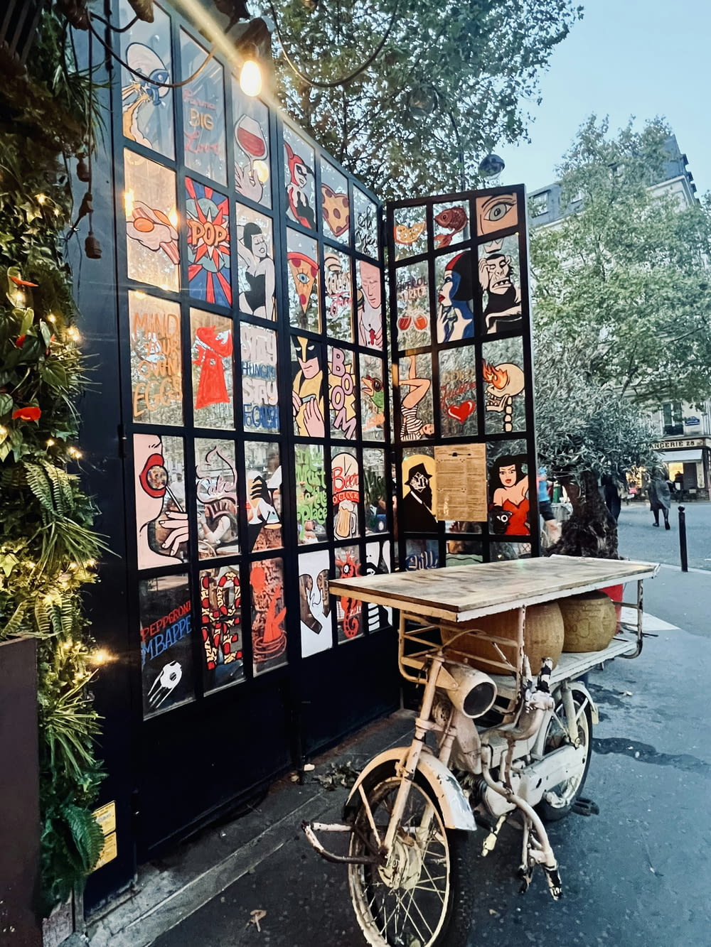 a bike parked next to a wall covered in pictures