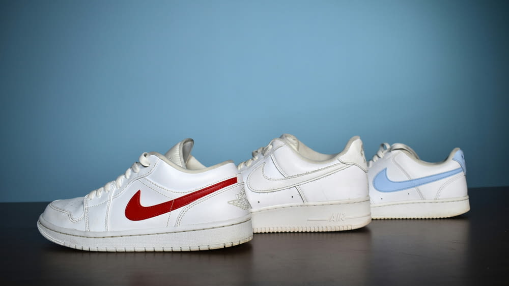 a pair of white sneakers with a red and blue nike logo