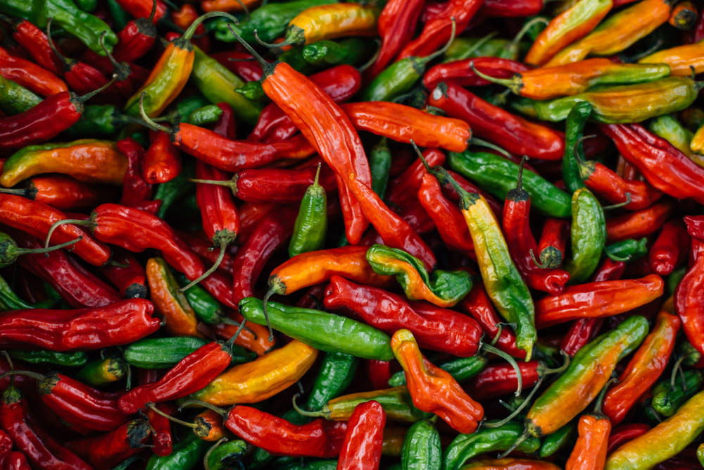 a large pile of red and green peppers